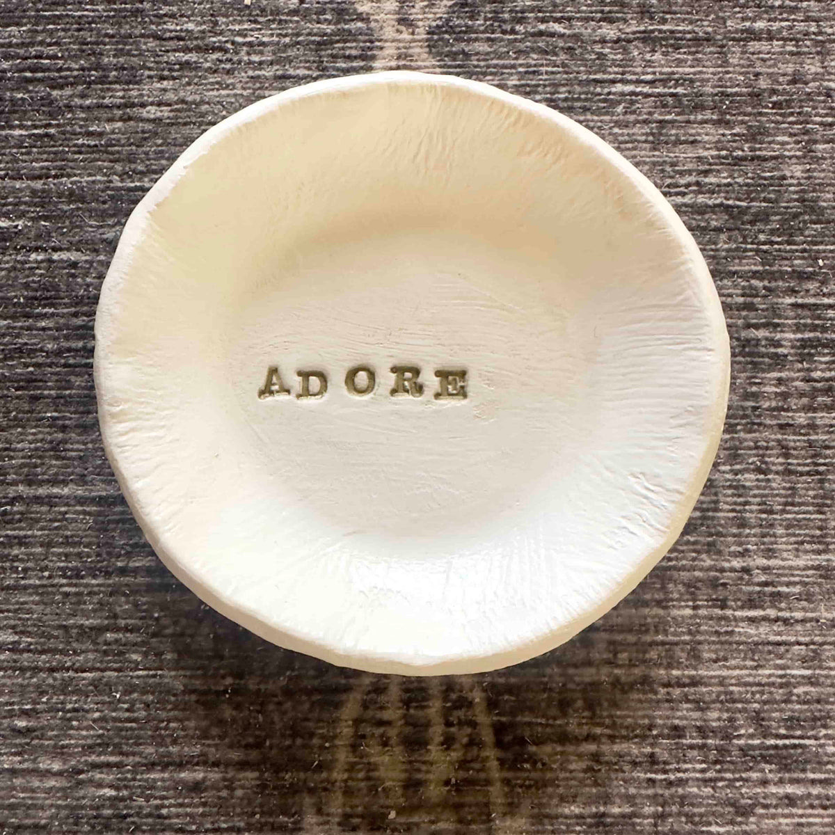round white trinket dish with the word adore in gold letters